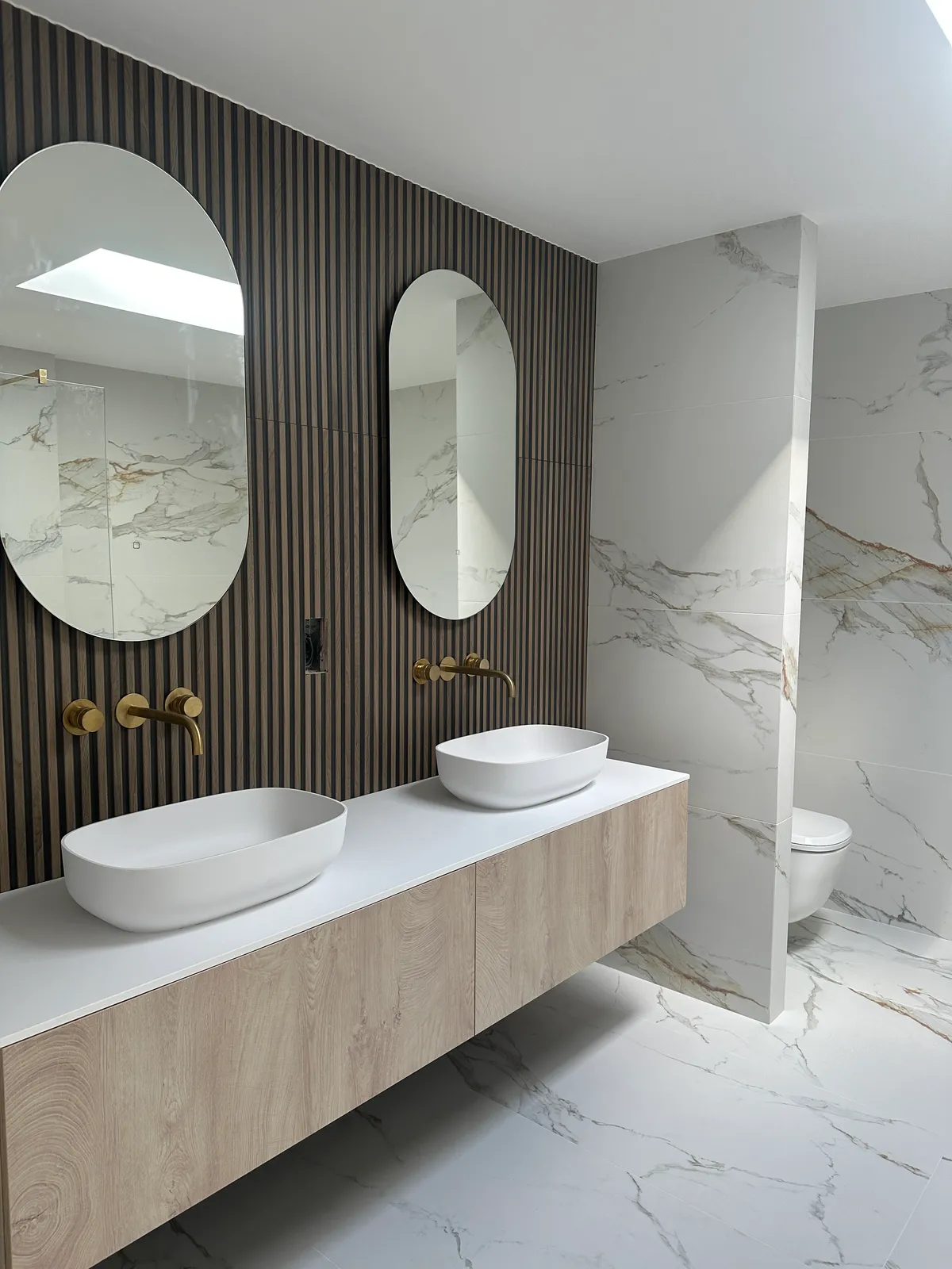 Bathroom installation with timber style and marbled tiles